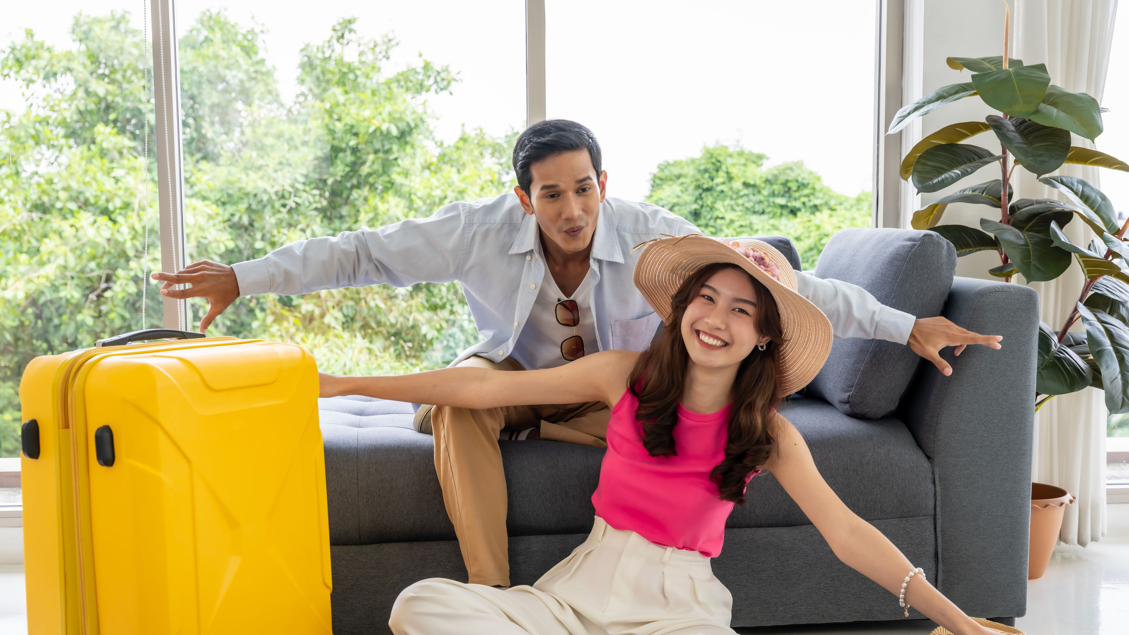 a happy asian couple posing together beside a yellow trolley 