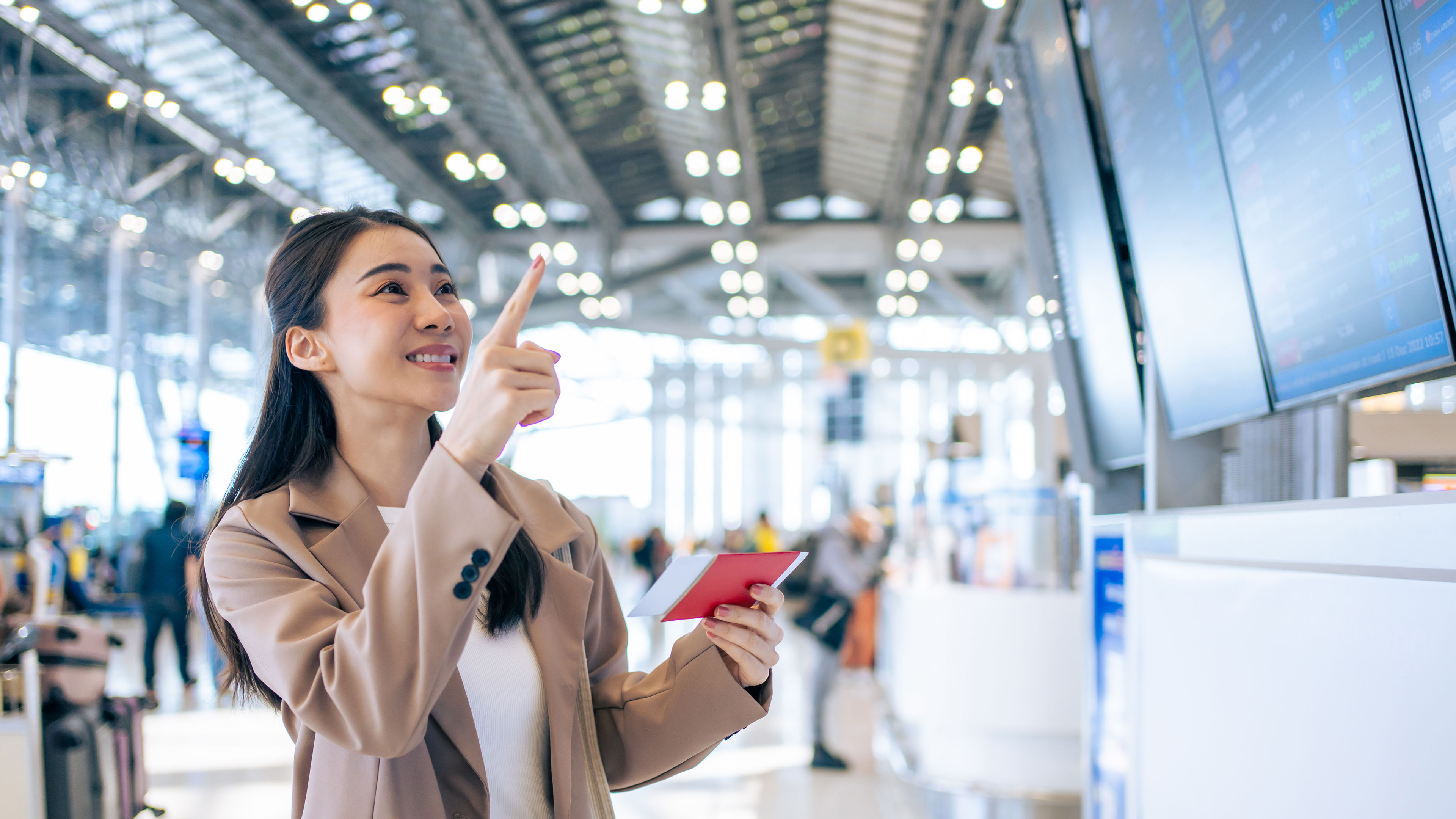 A smiling young woman at an airport points