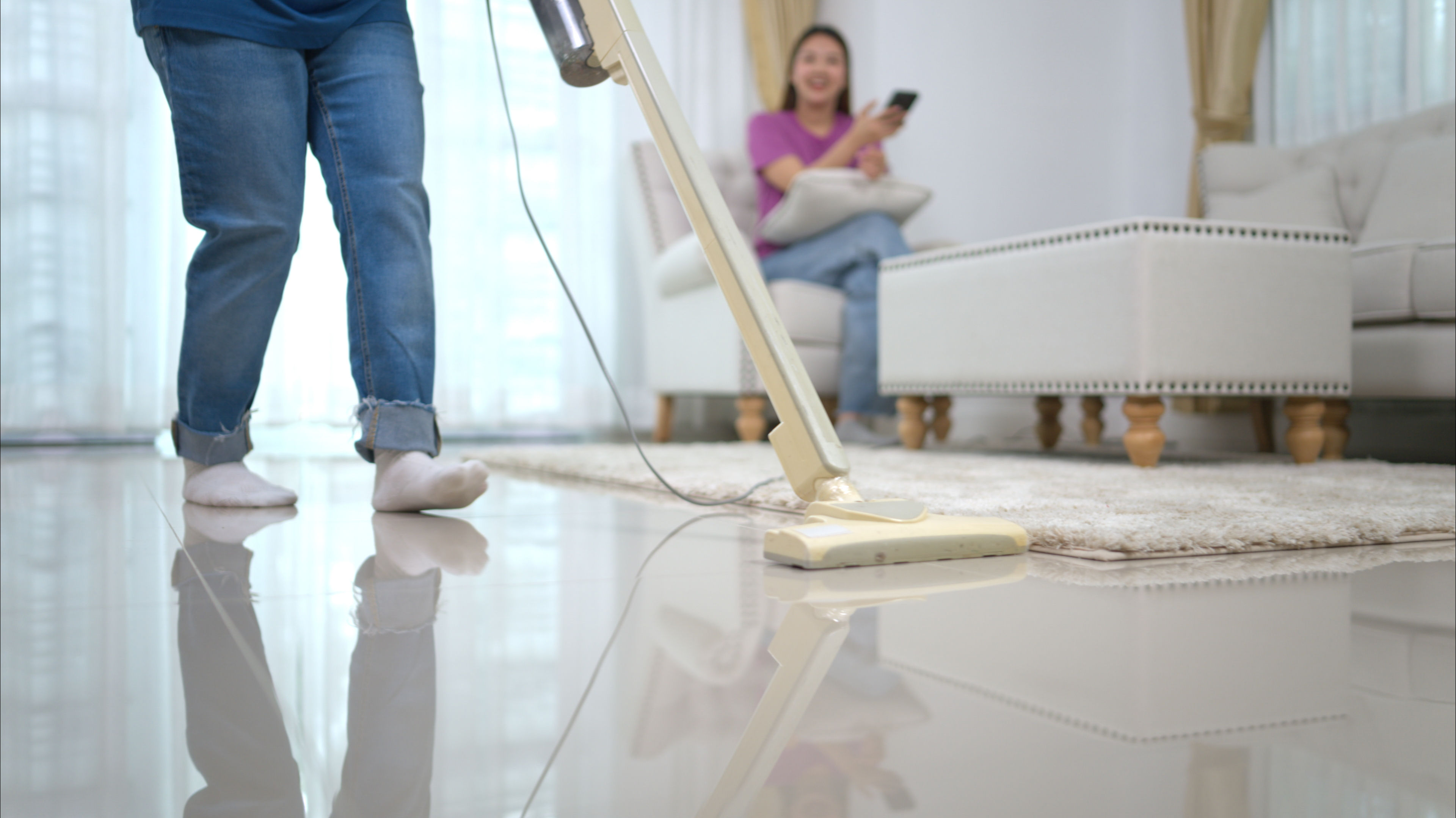 A woman cleans the house with a newly bought vacuum cleaner 