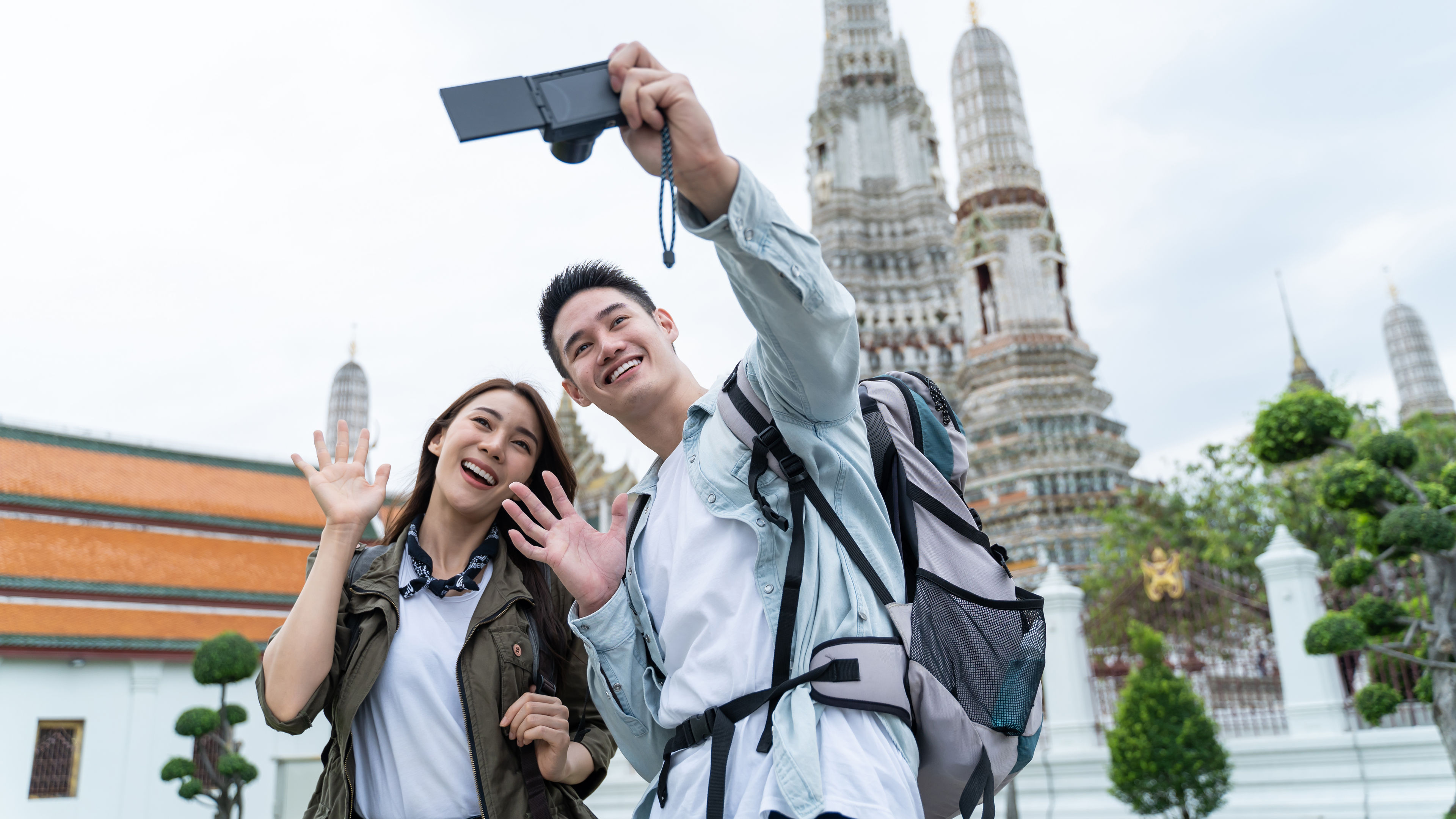 A young couple is outdoors, taking a selfie  