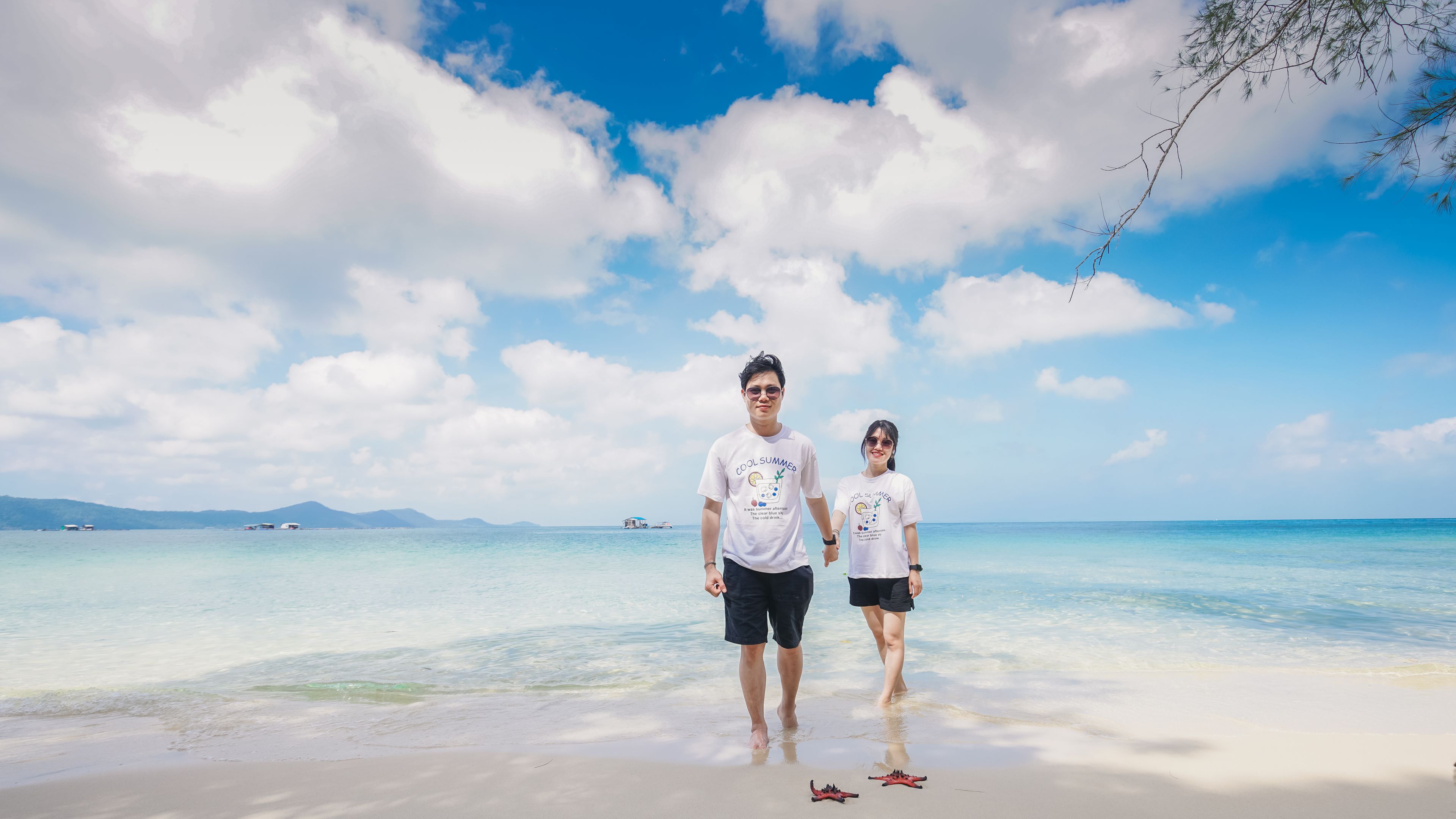 A couple walks hand in hand along the serene beach 