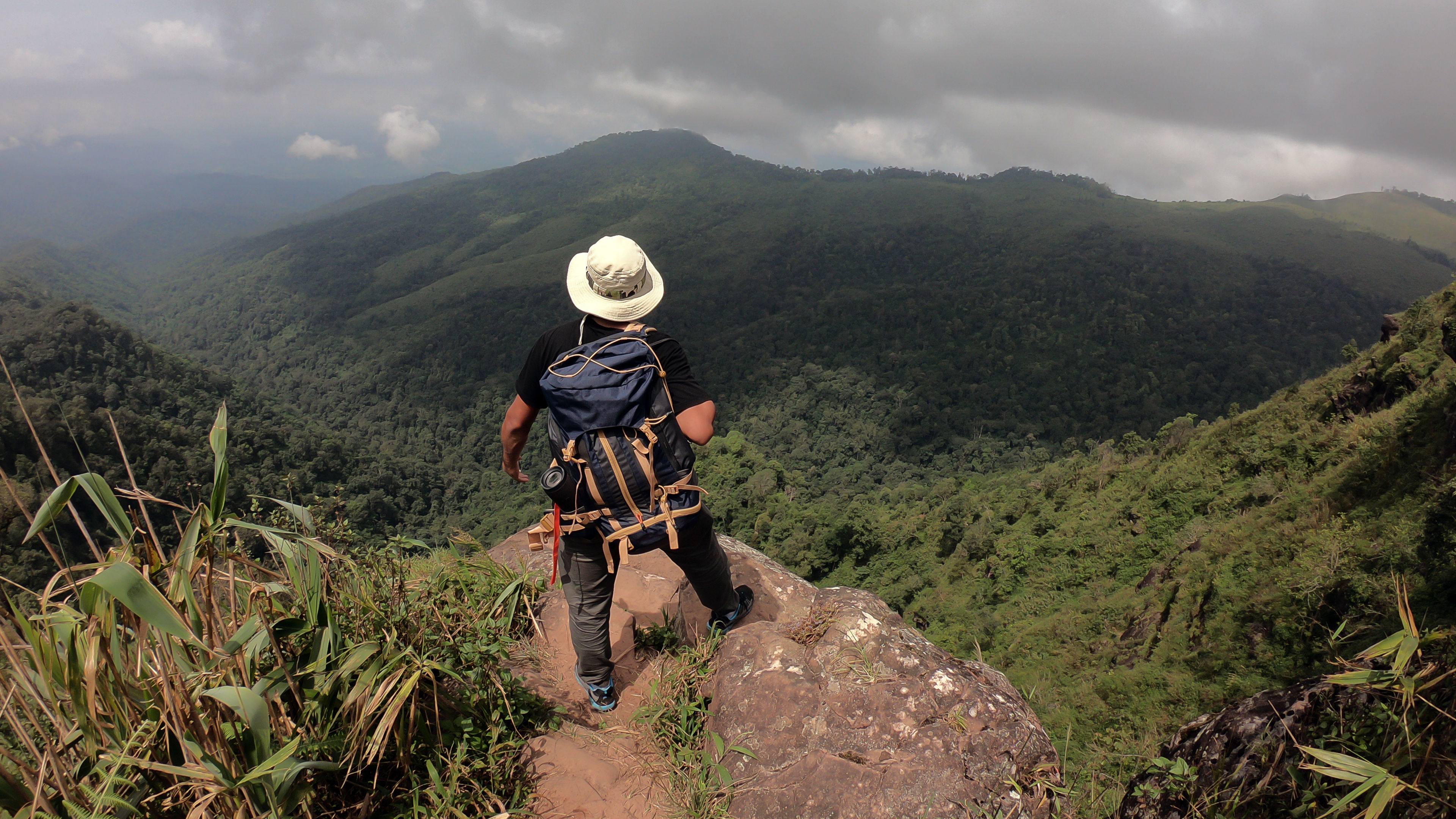 Man hold up hands on the peak of the mountain, success concept. 