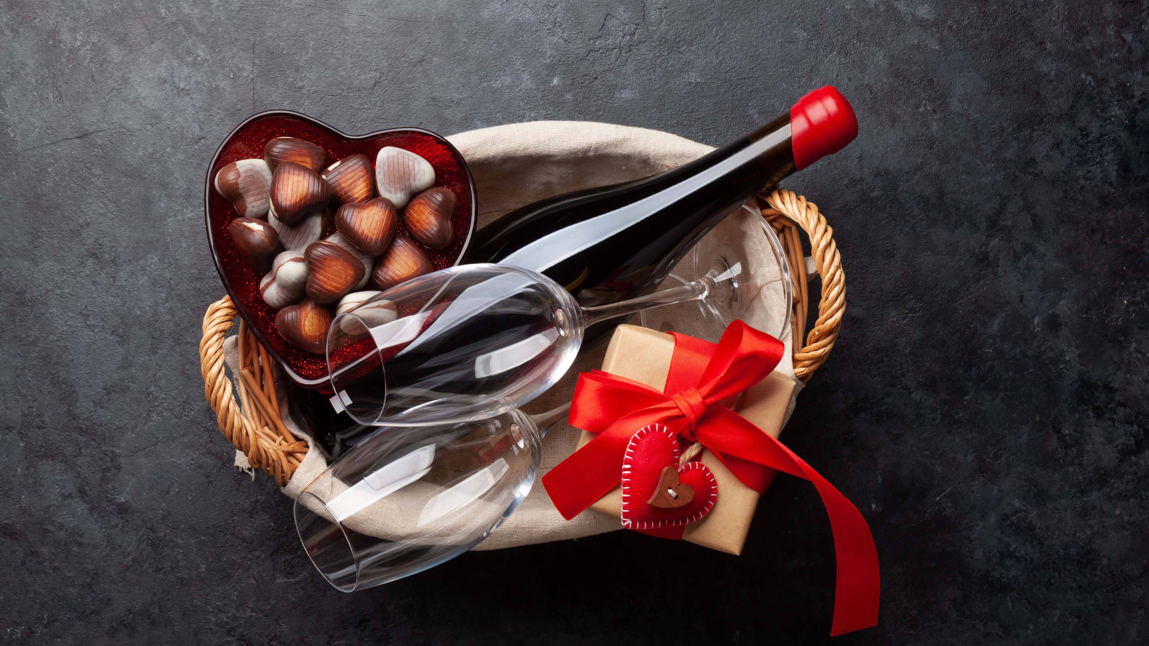 A gift hamper featuring a delightful combination of chocolates and wine makes for the perfect treat, blending sweet indulgence with a touch of sophistication. 