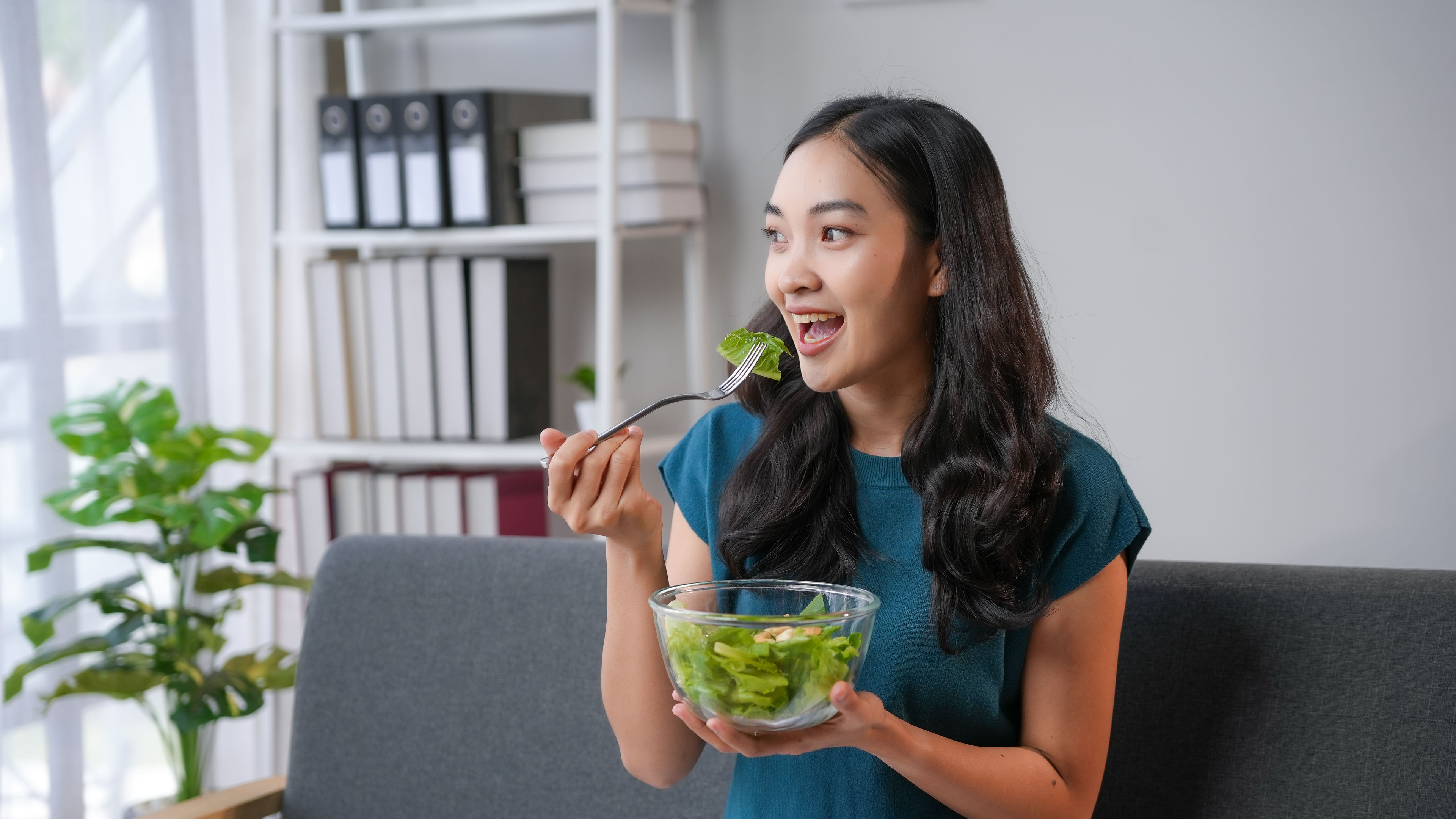 Woman eating a healthy bowl full of salad 