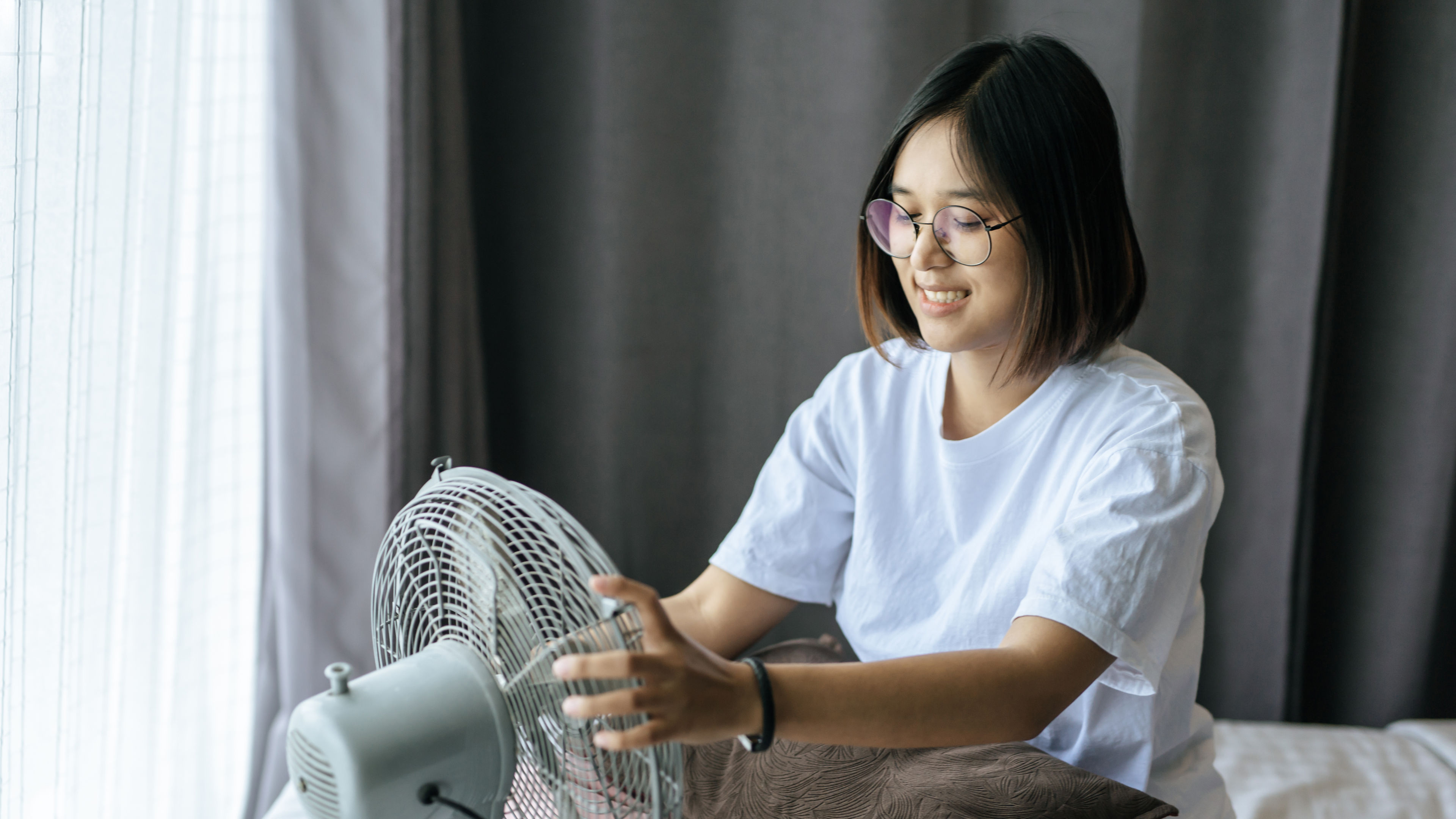 Woman in a white shirt checking the fan 