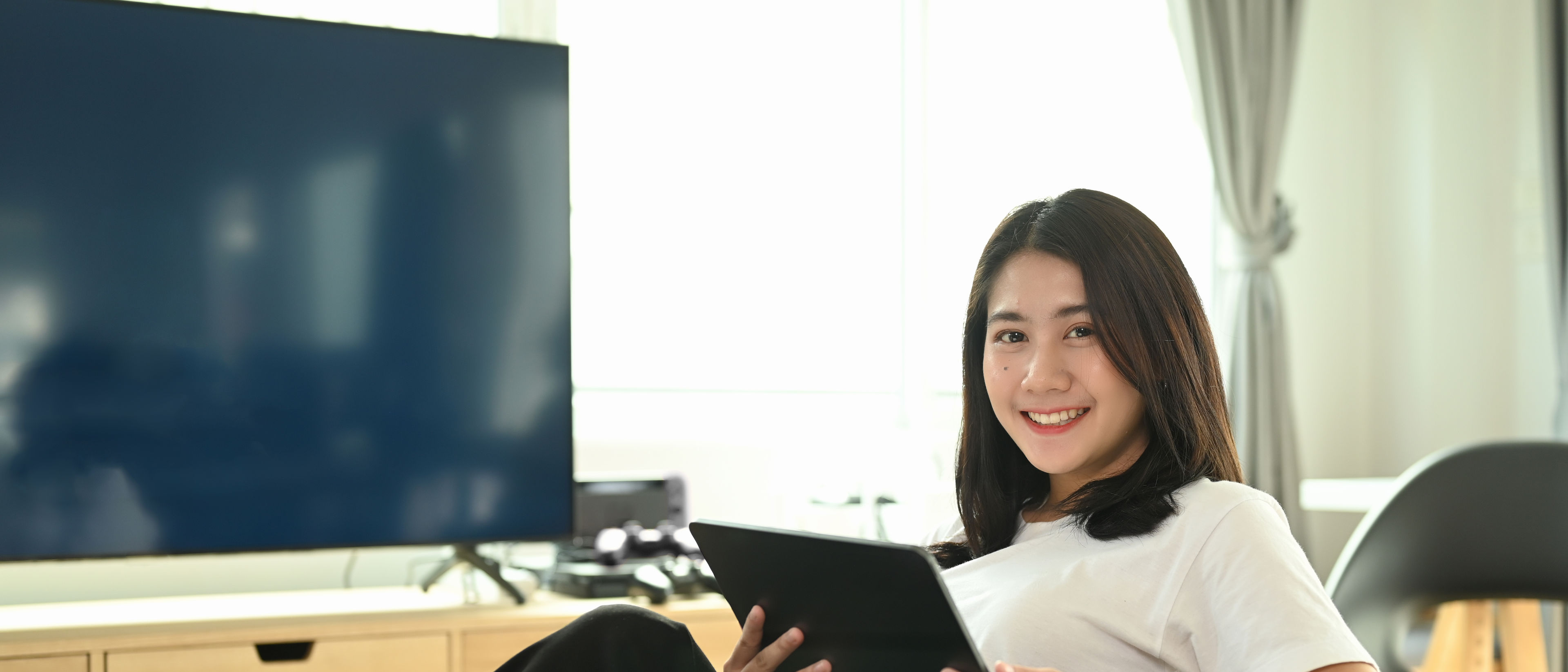 A woman is holding digital gadgets.