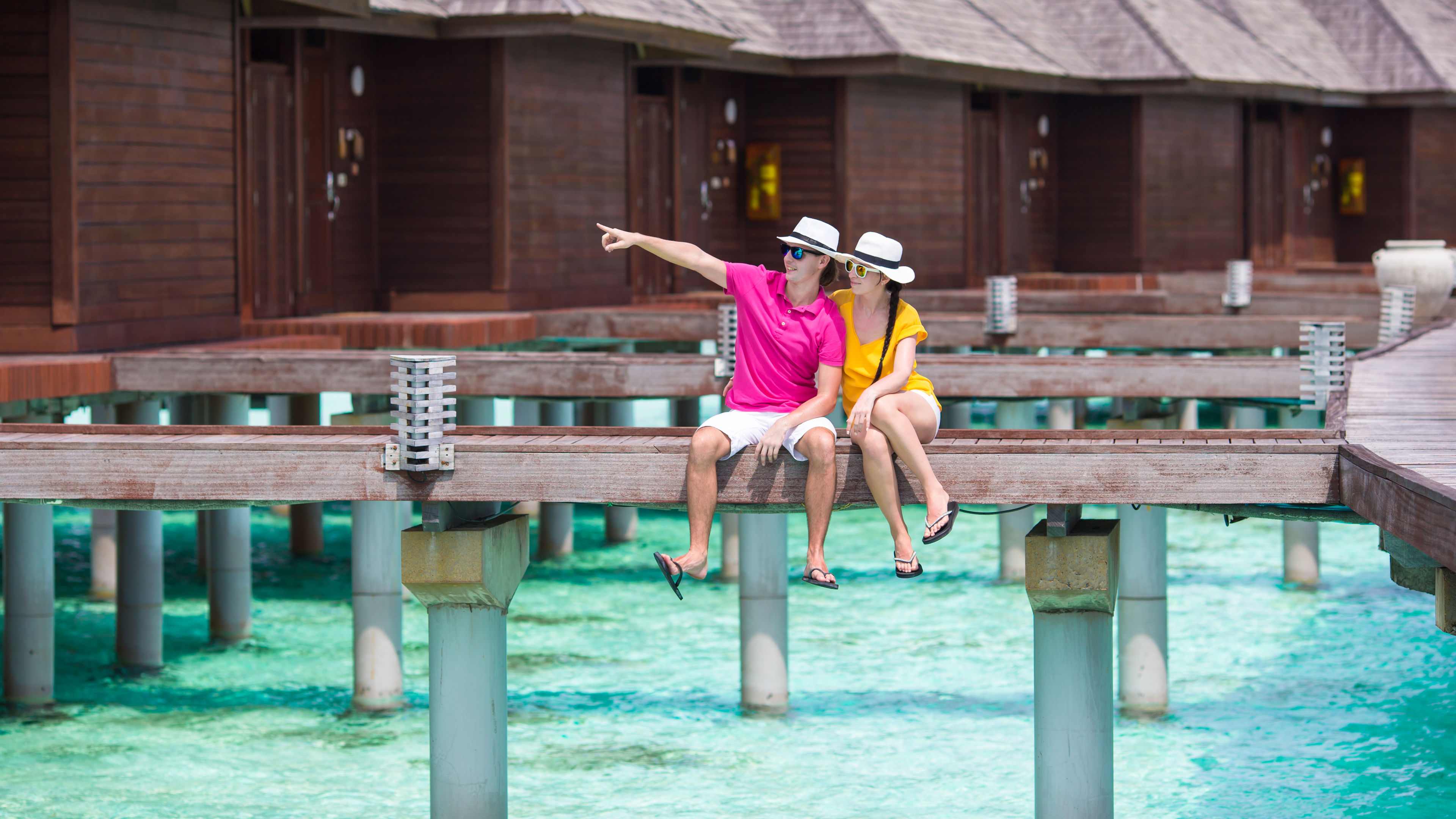 A couple enjoys the stunning views while relaxing by the resort's swimming pool. 